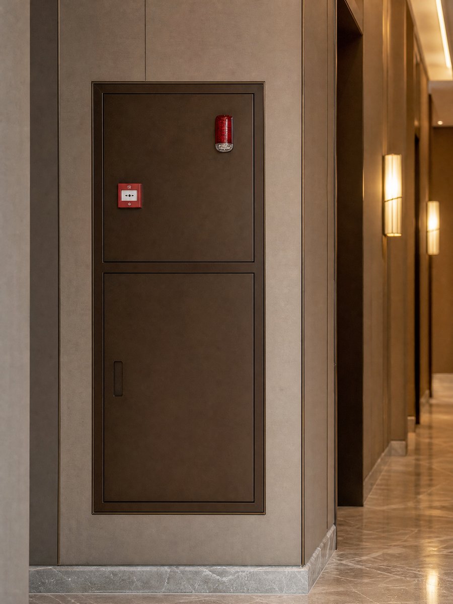 Recessed fire hose cabinet open showing landing valve, hose and swing-out reel